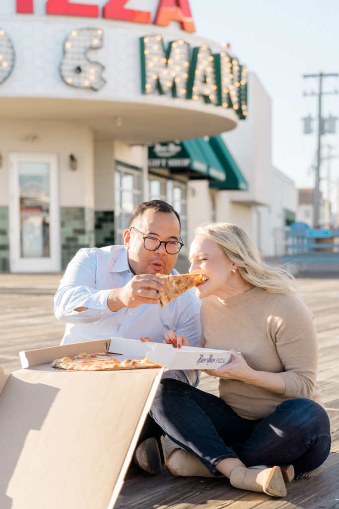 Couple eating pizza on the boardwalk