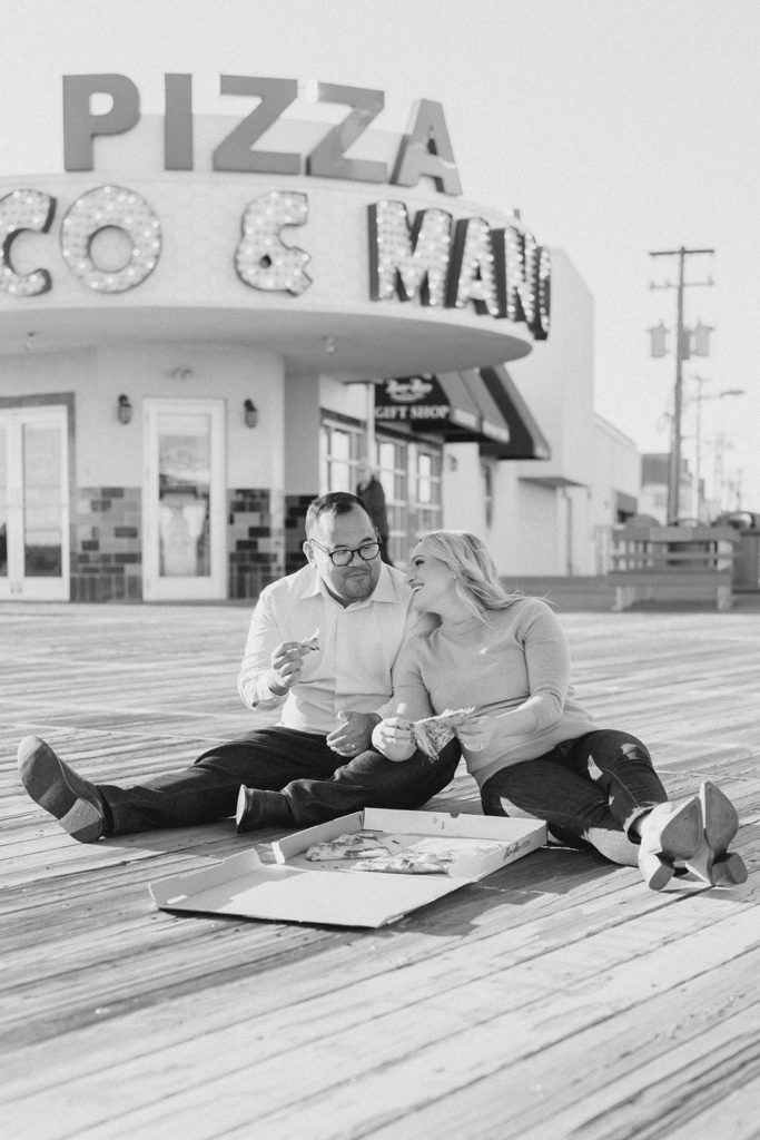Couple eating pizza on the boardwalk