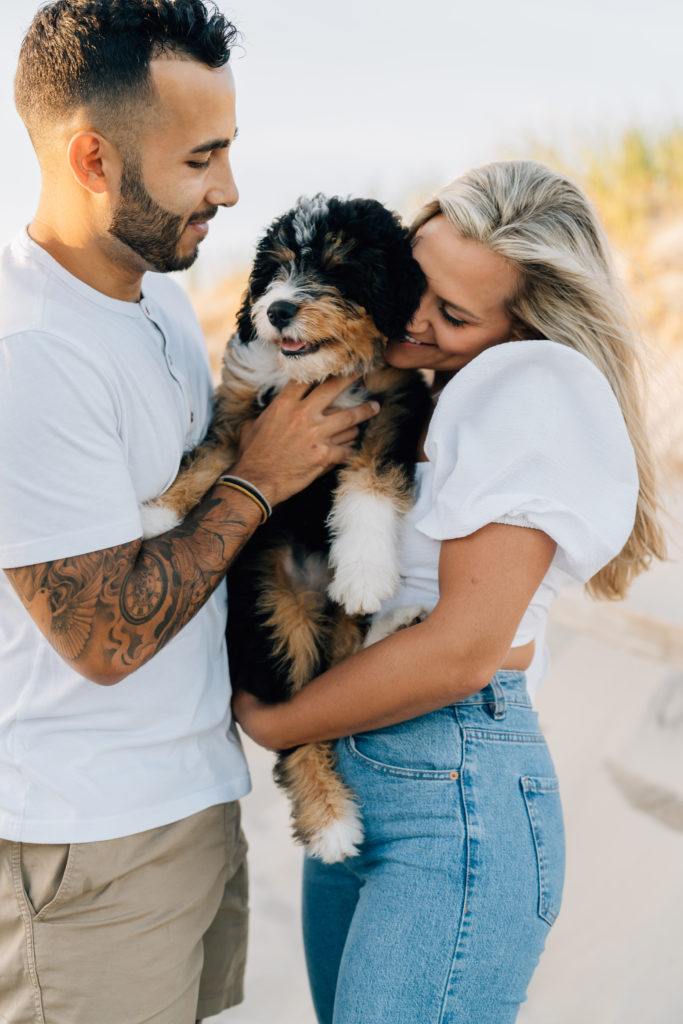 Couple snuggles with dog at engagement session