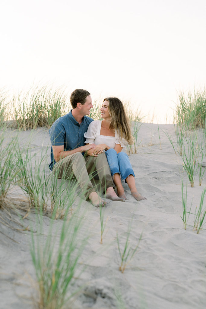 Couple sitting on the beach during their engagement session