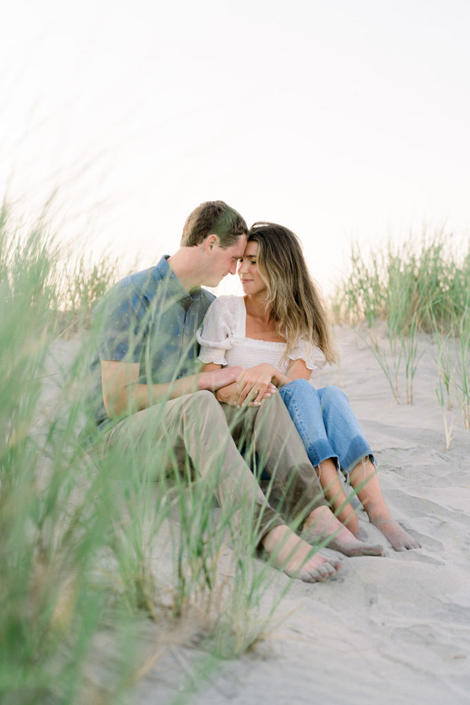 Couple sitting on the beach during their engagement session