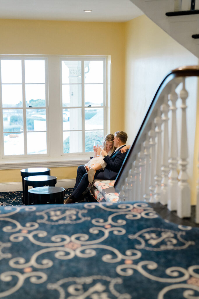 Newly engaged couple hugging, laughing, and kissing at Congress Hall in Cape May, New Jersey for their charming engagement session