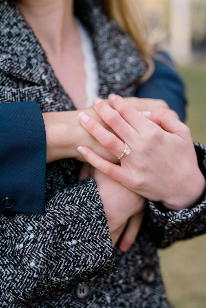 Newly engaged couple hugging and showing engagement ring outside of Congress Hall in Cape May, New Jersey
