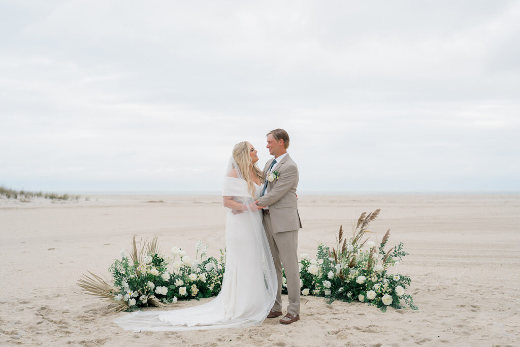 The ultimate guide to beach weddings in Cape May. Bride and groom standing on beach at ceremony in Cape May